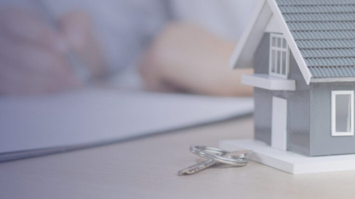 House model and keys beside legal paperwork representing a Declaration of Trust for jointly owned property.
